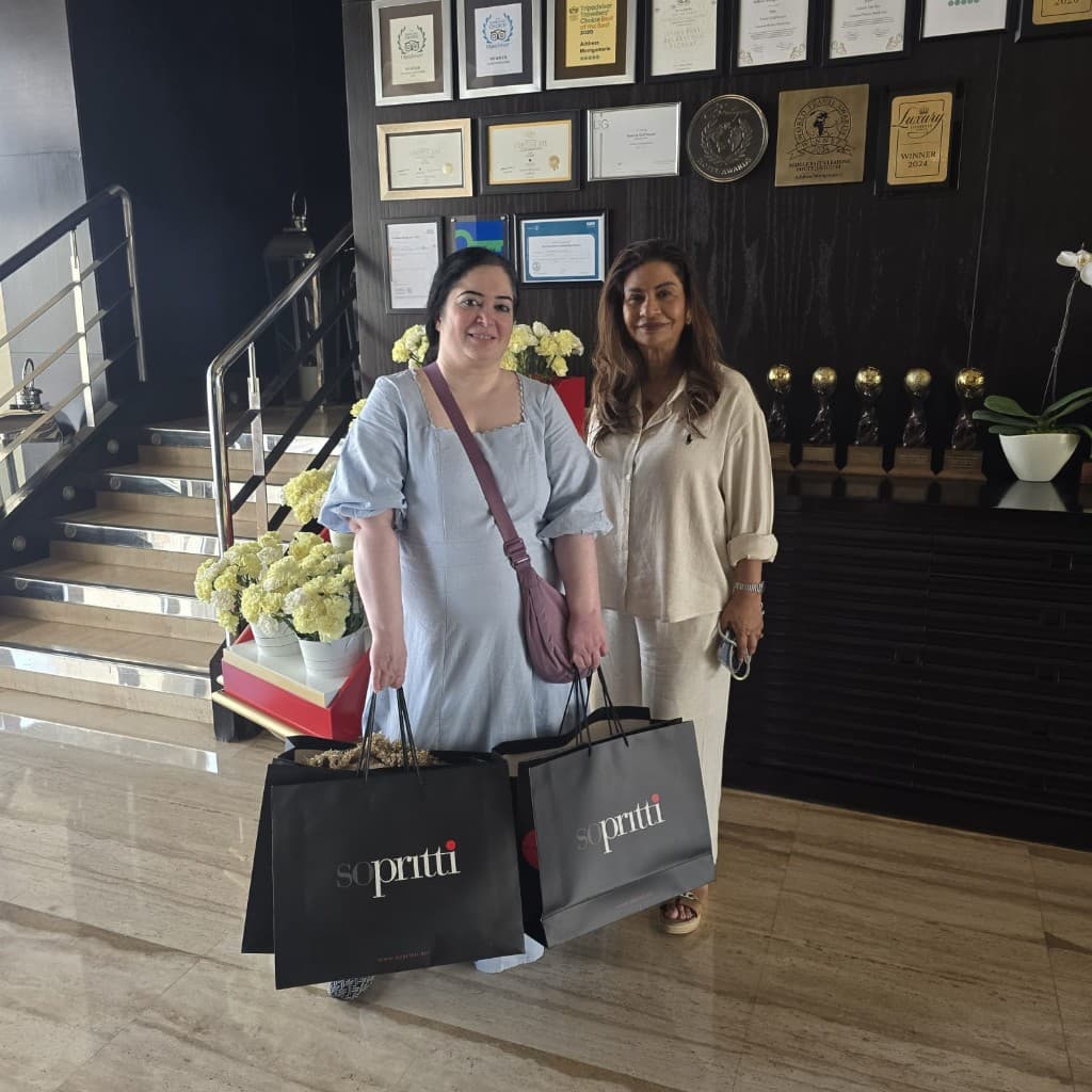 Guests with Sopritti shopping bags in front of an awards wall at a Dubai venue
